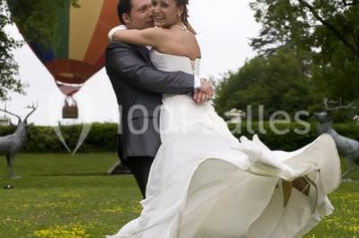 Un parc de nuit avec des arbres sombres, une structure lumineuse orange et des chemins faiblement éclairés.