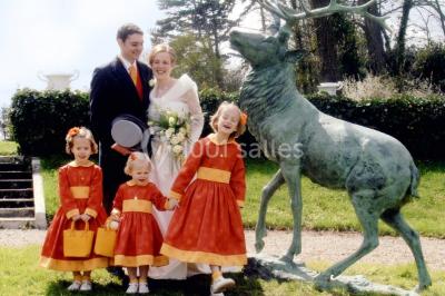 Un parc de nuit avec des arbres sombres, une structure lumineuse orange et des chemins faiblement éclairés.