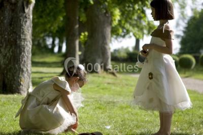 Un parc de nuit avec des arbres sombres, une structure lumineuse orange et des chemins faiblement éclairés.