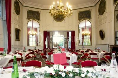 Un parc de nuit avec des arbres sombres, une structure lumineuse orange et des chemins faiblement éclairés.