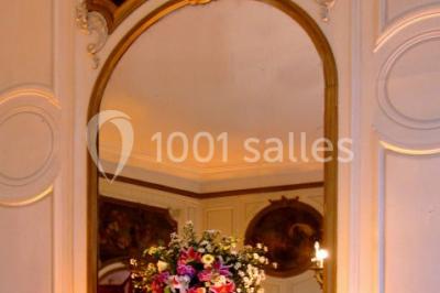 Un parc de nuit avec des arbres sombres, une structure lumineuse orange et des chemins faiblement éclairés.