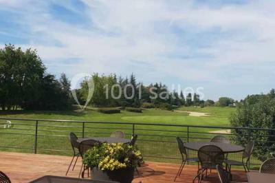 Vue d'un terrain de golf avec un green bien entretenu, entouré d'arbres et éclairé par une lumière douce en fin de journée.