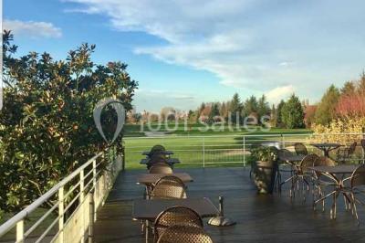 Vue d'un terrain de golf avec un green bien entretenu, entouré d'arbres et éclairé par une lumière douce en fin de journée.