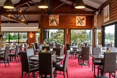 Vue d'un terrain de golf avec un green bien entretenu, entouré d'arbres et éclairé par une lumière douce en fin de journée.