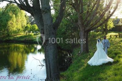 Bâtiment blanc moderne à deux étages avec colonnes, grandes fenêtres et espace paysager à l'avant.