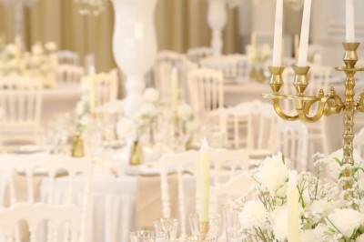 Bâtiment blanc moderne à deux étages avec colonnes, grandes fenêtres et espace paysager à l'avant.