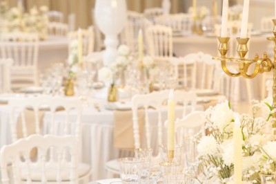 Bâtiment blanc moderne à deux étages avec colonnes, grandes fenêtres et espace paysager à l'avant.