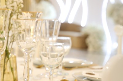 Bâtiment blanc moderne à deux étages avec colonnes, grandes fenêtres et espace paysager à l'avant.