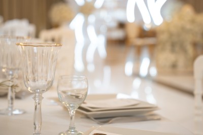 Bâtiment blanc moderne à deux étages avec colonnes, grandes fenêtres et espace paysager à l'avant.