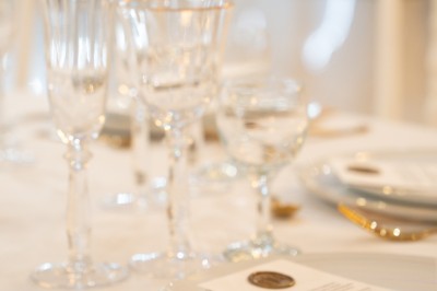 Bâtiment blanc moderne à deux étages avec colonnes, grandes fenêtres et espace paysager à l'avant.