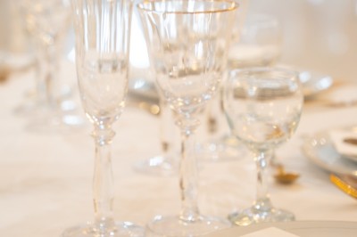 Bâtiment blanc moderne à deux étages avec colonnes, grandes fenêtres et espace paysager à l'avant.