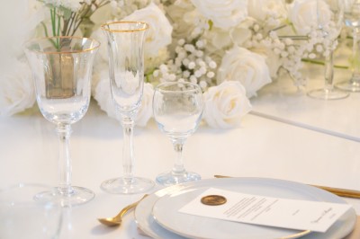 Bâtiment blanc moderne à deux étages avec colonnes, grandes fenêtres et espace paysager à l'avant.