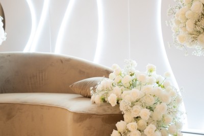 Bâtiment blanc moderne à deux étages avec colonnes, grandes fenêtres et espace paysager à l'avant.