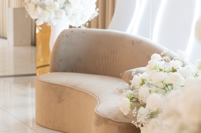 Bâtiment blanc moderne à deux étages avec colonnes, grandes fenêtres et espace paysager à l'avant.