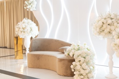 Bâtiment blanc moderne à deux étages avec colonnes, grandes fenêtres et espace paysager à l'avant.