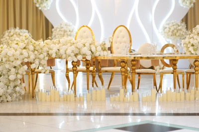 Bâtiment blanc moderne à deux étages avec colonnes, grandes fenêtres et espace paysager à l'avant.