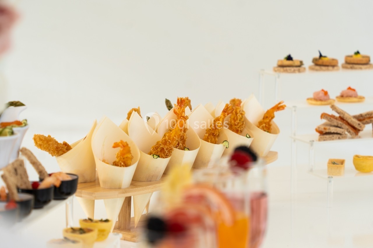 Assortiment de bouchées apéritives variées présentées sur des supports en bois et en verre.