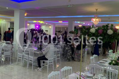 Buffet de desserts avec macarons colorés, verrines et pâtisseries disposés sur des présentoirs décoratifs dans une salle…