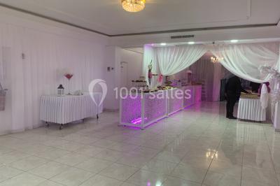 Buffet de desserts avec macarons colorés, verrines et pâtisseries disposés sur des présentoirs décoratifs dans une salle…