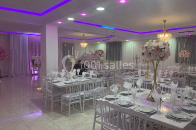 Buffet de desserts avec macarons colorés, verrines et pâtisseries disposés sur des présentoirs décoratifs dans une salle…
