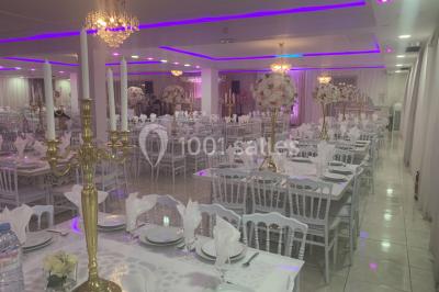 Buffet de desserts avec macarons colorés, verrines et pâtisseries disposés sur des présentoirs décoratifs dans une salle…