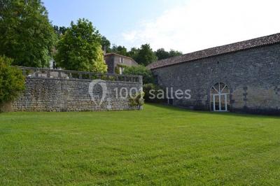 Arbre solitaire sans feuilles dans un champ givré au lever du jour, avec un chemin et des arbres en arrière-plan.