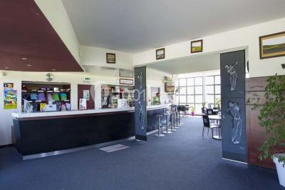 Terrasse en bois avec mobilier de jardin, vue sur un terrain de golf verdoyant par une journée ensoleillée.
