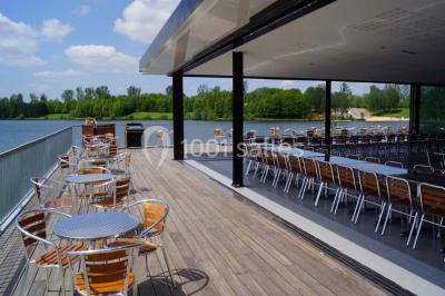 Terrasse en bois avec mobilier de jardin, vue sur un terrain de golf verdoyant par une journée ensoleillée.