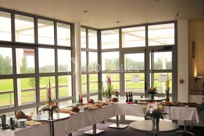 Terrasse en bois avec mobilier de jardin, vue sur un terrain de golf verdoyant par une journée ensoleillée.