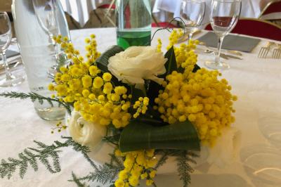 Salle lumineuse avec une grande table rectangulaire couverte d'une nappe bleue, entourée de chaises rouges, et une fenêtre…