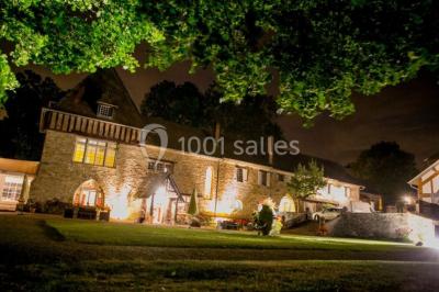 Salle lumineuse avec une grande table rectangulaire couverte d'une nappe bleue, entourée de chaises rouges, et une fenêtre…