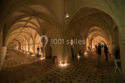 Chambre lumineuse avec lit double, mur beige capitonné, bureau minimaliste, chaise jaune et fenêtre à croisillons.