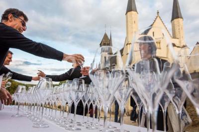 Chambre lumineuse avec lit double, mur beige capitonné, bureau minimaliste, chaise jaune et fenêtre à croisillons.