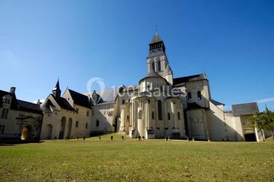 Chambre lumineuse avec lit double, mur beige capitonné, bureau minimaliste, chaise jaune et fenêtre à croisillons.