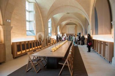 Chambre lumineuse avec lit double, mur beige capitonné, bureau minimaliste, chaise jaune et fenêtre à croisillons.