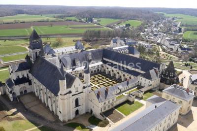 Chambre lumineuse avec lit double, mur beige capitonné, bureau minimaliste, chaise jaune et fenêtre à croisillons.