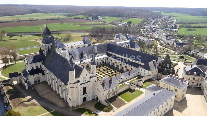 Vue aérienne d'une abbaye historique entourée de jardins, de bâtiments annexes et de paysages ruraux verdoyants.