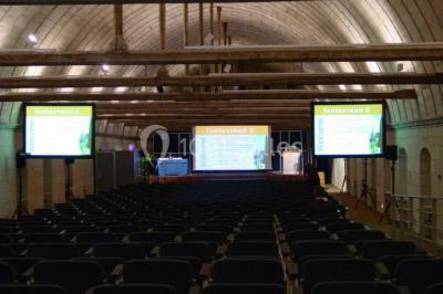 Chambre lumineuse avec lit double, mur beige capitonné, bureau minimaliste, chaise jaune et fenêtre à croisillons.