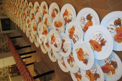 Assiettes alignées contenant du saumon fumé, des tranches de citron, une sauce et une garniture sur une longue table.