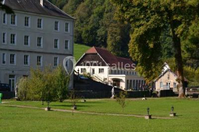 Miniature Location salle Guillon-les-Bains (Doubs) - Domaine Les Bains #7 Cuisine professionnelle équipée de plans de travail en inox, fours, étagères métalliques et carrelage mural blanc.