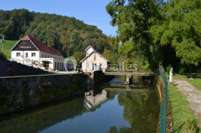 Miniature Location salle Guillon-les-Bains (Doubs) - Domaine Les Bains #5 Cuisine professionnelle équipée de plans de travail en inox, fours, étagères métalliques et carrelage mural blanc.