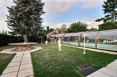 Salle de bain lumineuse avec baignoire encastrée sur estrade carrelée, poutres apparentes et grande fenêtre.