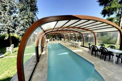 Salle de bain lumineuse avec baignoire encastrée sur estrade carrelée, poutres apparentes et grande fenêtre.