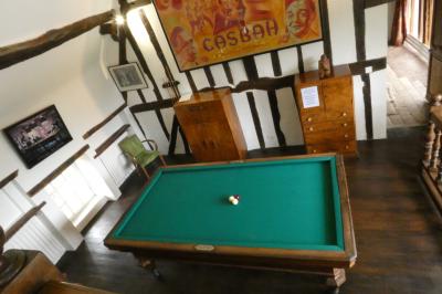 Salle de bain lumineuse avec baignoire encastrée sur estrade carrelée, poutres apparentes et grande fenêtre.