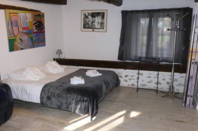 Salle de bain lumineuse avec baignoire encastrée sur estrade carrelée, poutres apparentes et grande fenêtre.