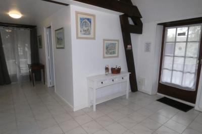 Salle de bain lumineuse avec baignoire encastrée sur estrade carrelée, poutres apparentes et grande fenêtre.