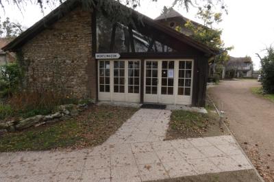 Salle de bain lumineuse avec baignoire encastrée sur estrade carrelée, poutres apparentes et grande fenêtre.