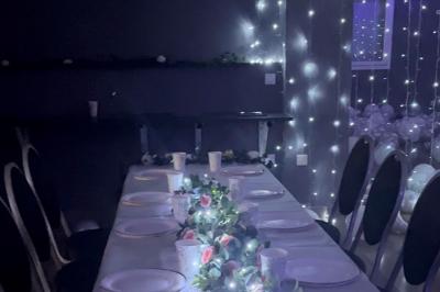 Structure métallique suspendue avec projecteurs, spots et boules à facettes dans une salle au plafond blanc.