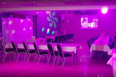 Structure métallique suspendue avec projecteurs, spots et boules à facettes dans une salle au plafond blanc.