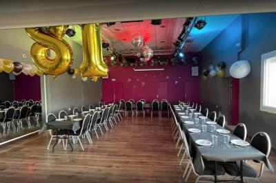 Structure métallique suspendue avec projecteurs, spots et boules à facettes dans une salle au plafond blanc.